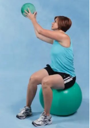 ổn định và thăng bằng người phụ nữ ngồi trên quả bóng đưa quả bóng nhỏ hơn lên cao